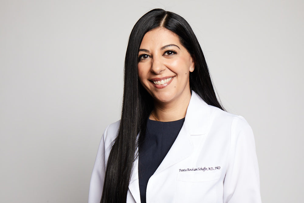 Person wearing a white coat with a plain background